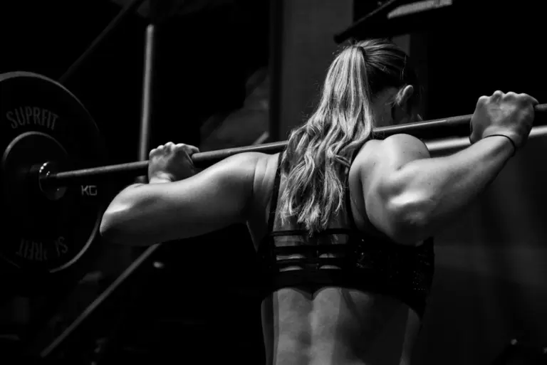 Athlète réalisant un squat avec une barre au Capsule Club.