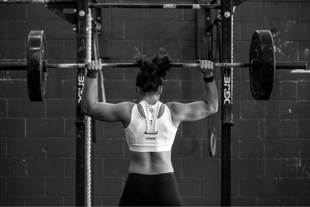 Latihan back squat dengan barbel olimpik di Capsule Club.