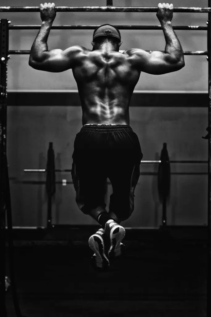 Homme effectuant une traction sur une barre dans une salle de sport.