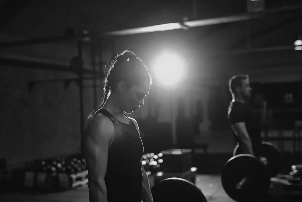 Deux athlètes se préparant à soulever une barre lors d'une séance de musculation en salle.