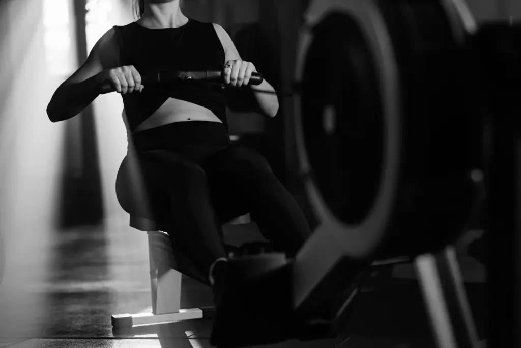 Athlète utilisant un rameur pendant une séance d'entraînement en salle.