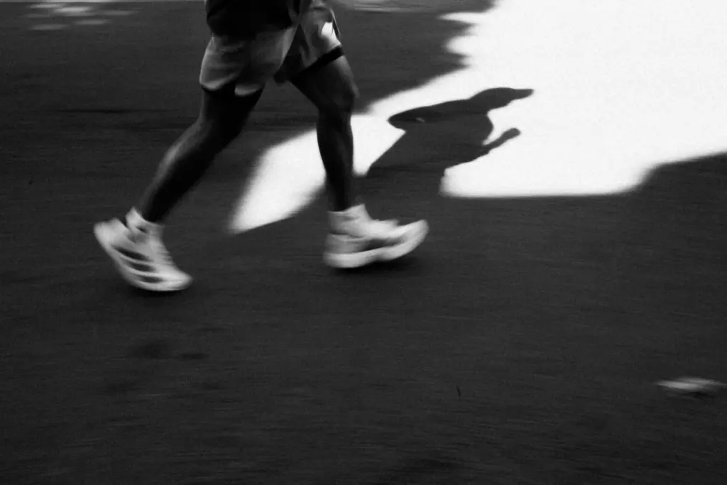 Coureur en mouvement sur la route, capturé en gros plan pendant une séance de course à pied.
